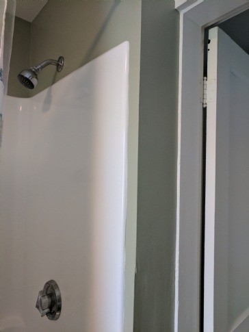 Add pocket door in wall behind shower head and plumbing