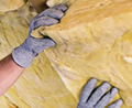 Contractor installing attic insulation